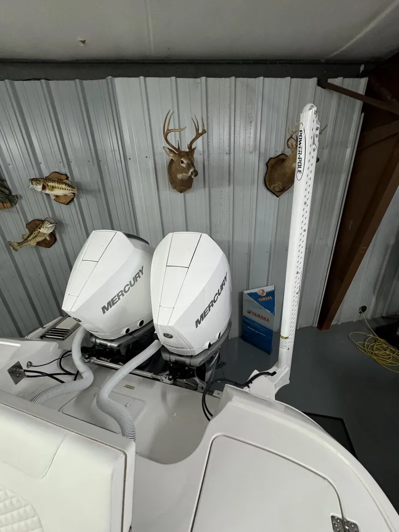 Slide: The Image of 2025 Caymas 281 HB boat with dual Mercury engines in a garage setting. - 27