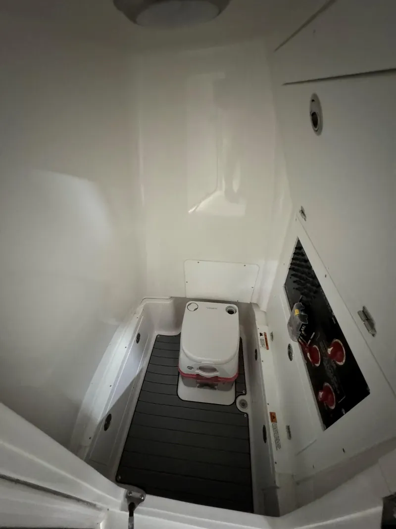 Slide: The Image of 2025 Caymas 281 HB boat interior with compact marine toilet and control panel. - 28