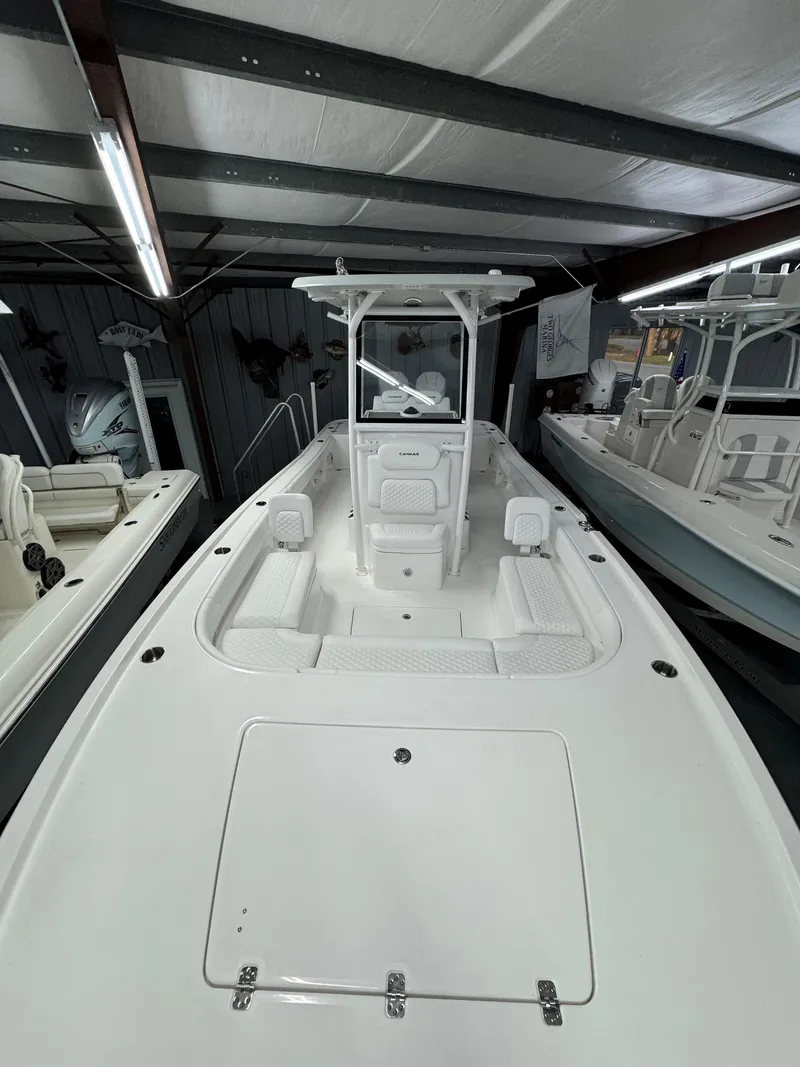 Slide: The Image of 2025 Caymas 281 HB boat in showroom, featuring sleek white design and spacious deck. - 31
