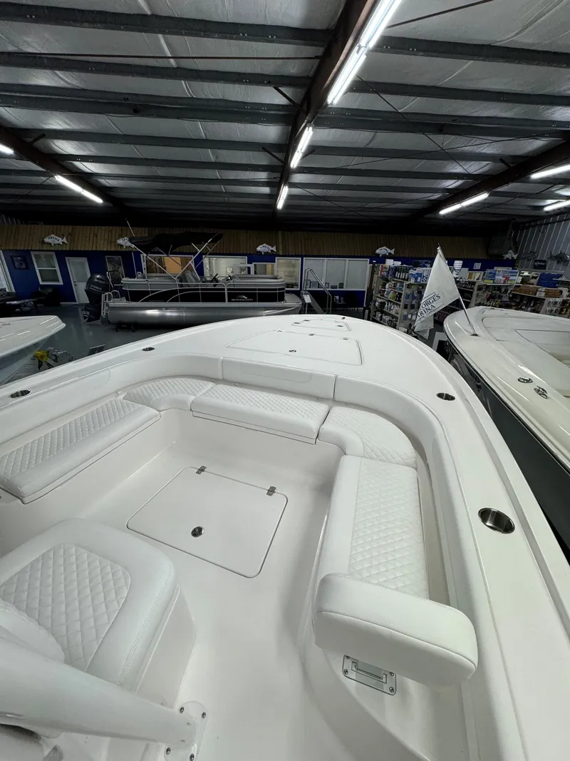 Slide: The Image of 2025 Caymas 281 HB boat interior with white seating in a showroom. - 32