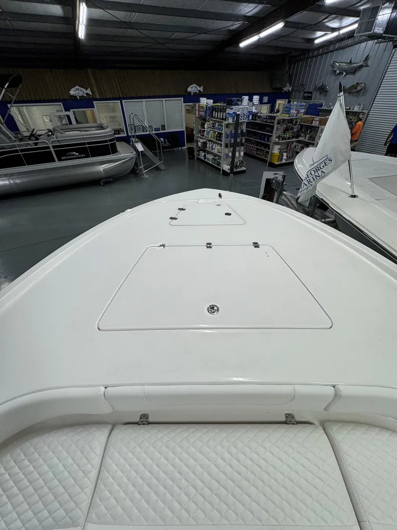 Slide: The Image of 2025 Caymas 281 HB boat deck in showroom, featuring sleek design and storage compartments. - 34
