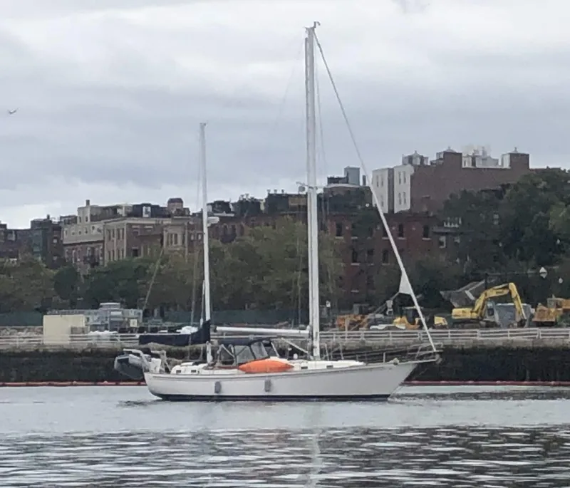 Slide: The Image of 1984 Whitby 42 Ketch sailboat docked near urban waterfront. - 11