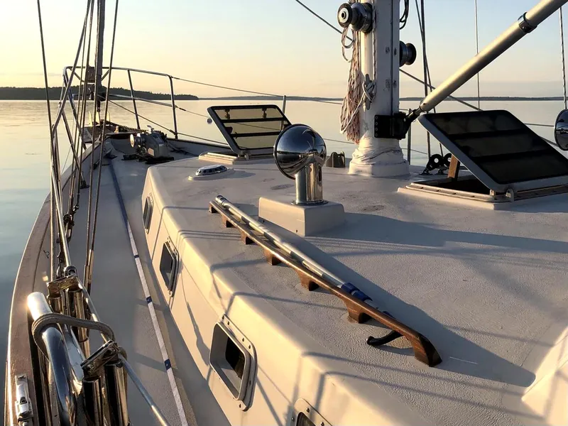 Slide: The Image of 1984 Whitby 42 Ketch sailboat deck at sunset, calm waters, elegant design. - 12