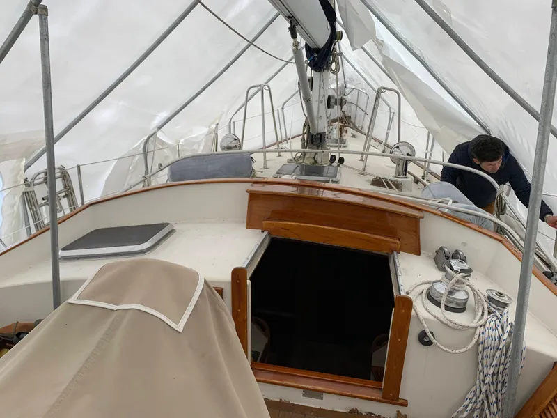 Slide: The Image of 1984 Whitby 42 Ketch sailboat under protective cover, showing deck and cockpit area. - 16