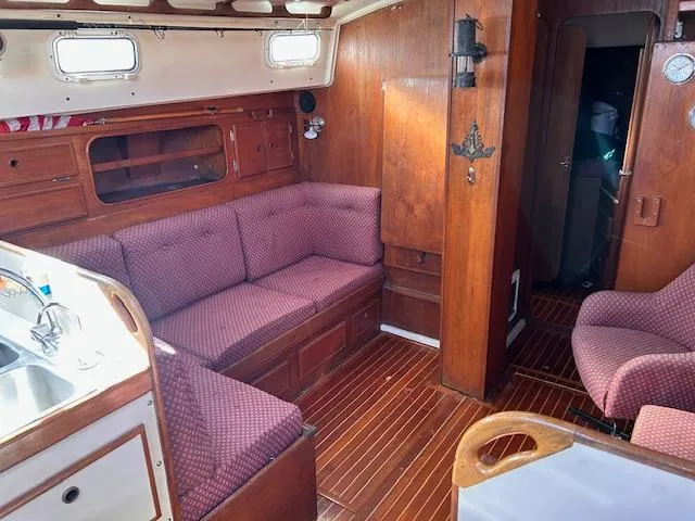 Slide: The Image of Interior of 1984 Whitby 42 Ketch with wooden finish and red upholstered seating. - 19