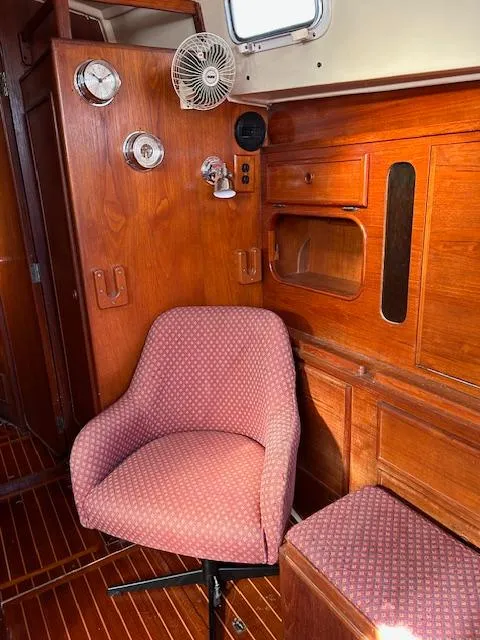 Slide: The Image of Cozy interior of 1984 Whitby 42 Ketch with wooden paneling and pink upholstered chair. - 21