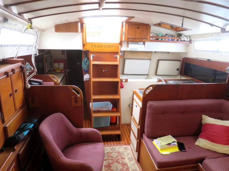 Slide: The Image of Interior of 1984 Whitby 42 Ketch sailboat, featuring cozy seating and wooden cabinetry. - 24
