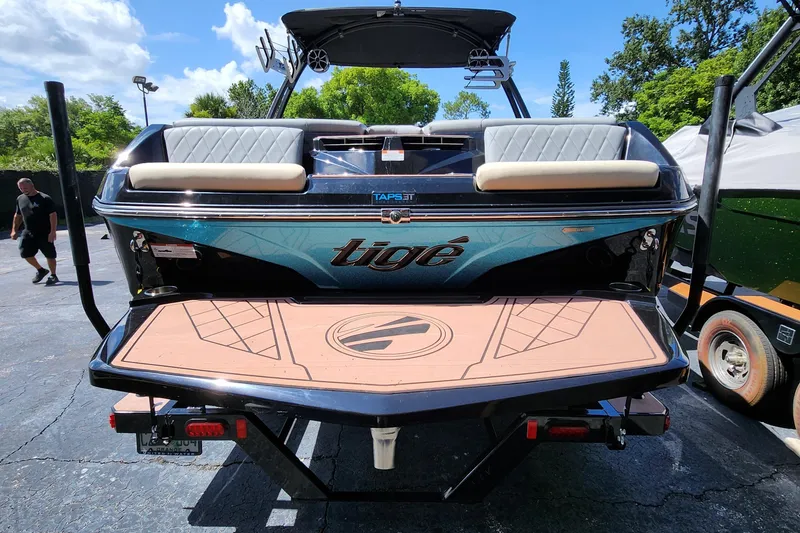 Slide: The Image of 2022 Tigé Z1 boat rear view with swim platform and seating, parked outdoors. - 3
