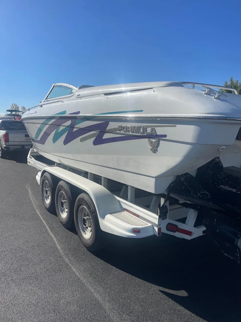 Slide: The Image of 1998 Formula 312FASTECH boat on a trailer, parked on a sunny day. - 2