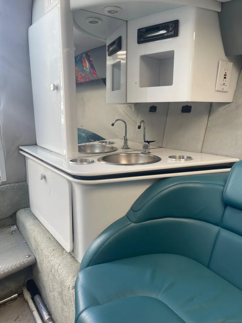 Slide: The Image of Interior of a 1998 Formula 312FASTECH boat with kitchenette and teal seating. - 20