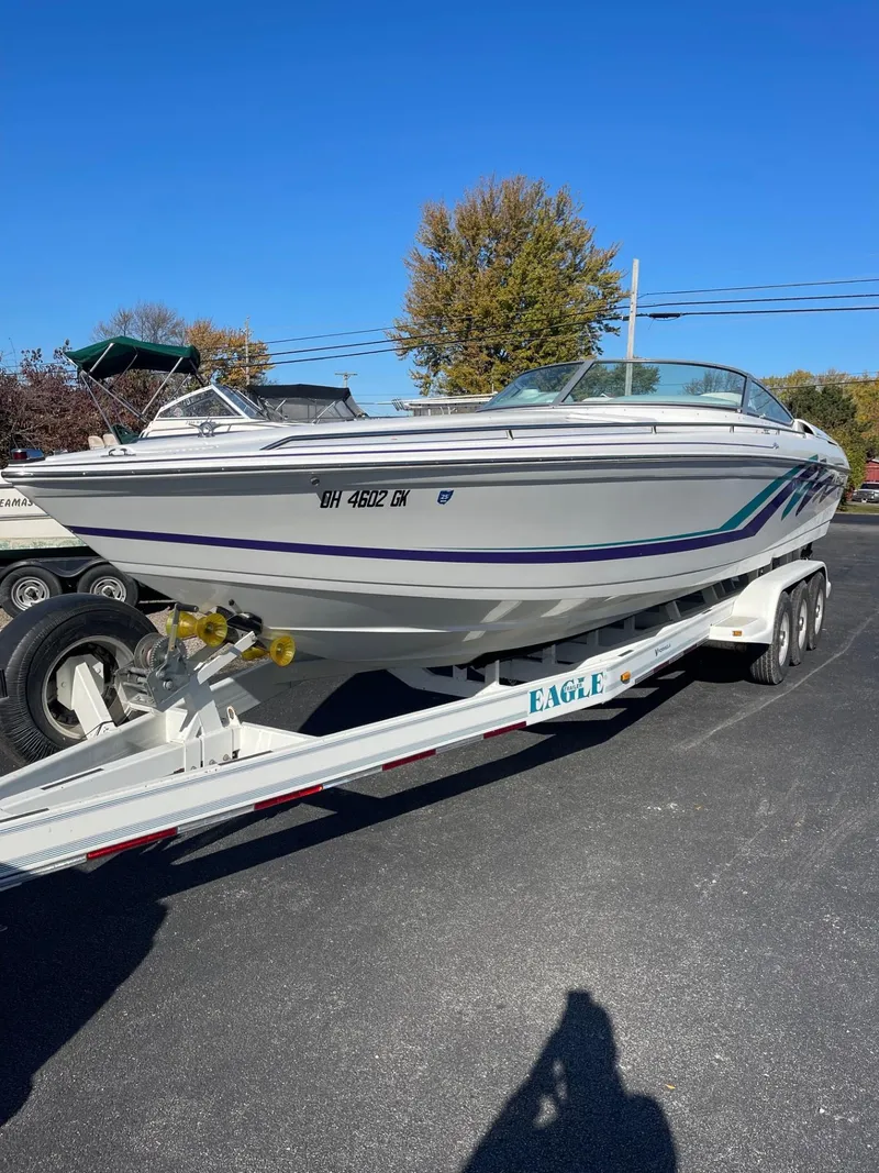 Slide: The Image of 1998 Formula 312FASTECH boat on trailer, parked outdoors under clear blue sky. - 34