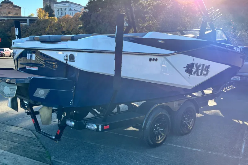 Slide: The Image of 2024 Axis T 220 boat on trailer, parked outdoors in sunny setting. - 11