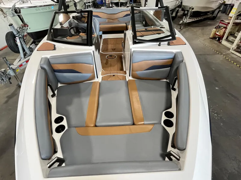 Slide: The Image of 2024 Axis T 220 boat interior with gray and brown seating, cup holders, and windshield. - 6