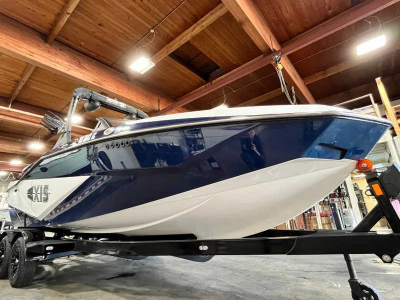 Slide: The Image of 2024 Axis T 220 boat in a wooden ceiling showroom, blue and white design. - 8