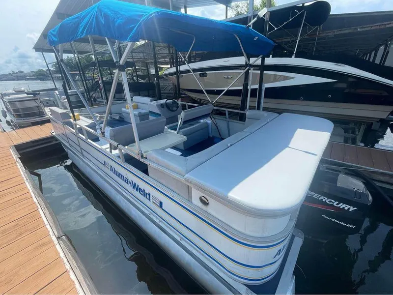 Slide: The Image of 1994 Alumaweld Getaway boat with blue canopy docked at marina. - 10