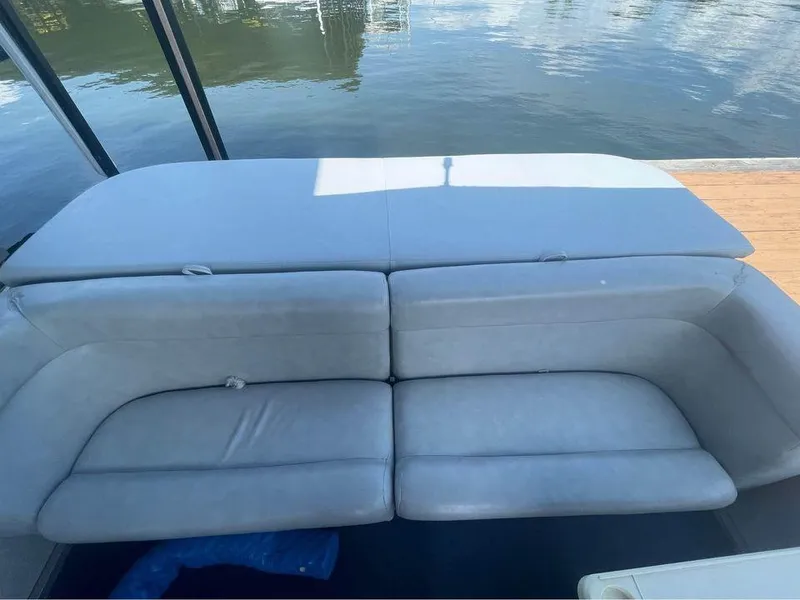 Slide: The Image of 1994 Alumaweld Getaway boat with gray cushioned seating by the water. - 11