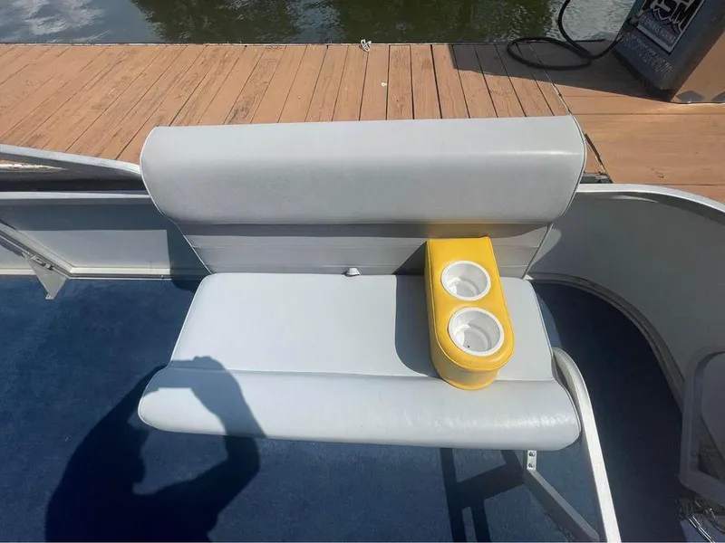 Slide: The Image of 1994 Alumaweld Getaway boat seat with yellow cup holder on a sunny day. - 4