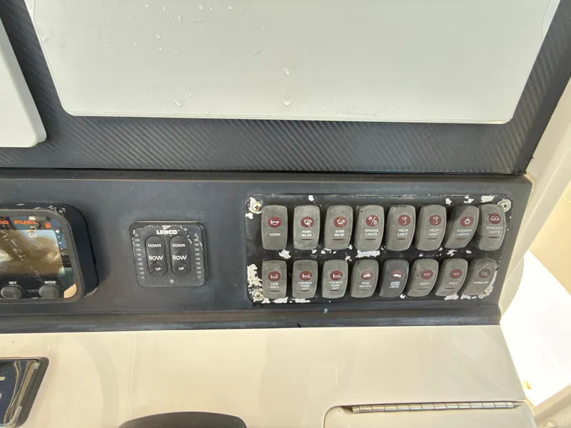 Slide: The Image of Control panel of a 2008 Jupiter 38 boat with various switches and buttons. - 13