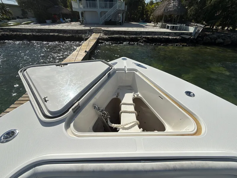 Slide: The Image of Open anchor compartment on 2008 Jupiter 38 boat docked by a wooden pier. - 18