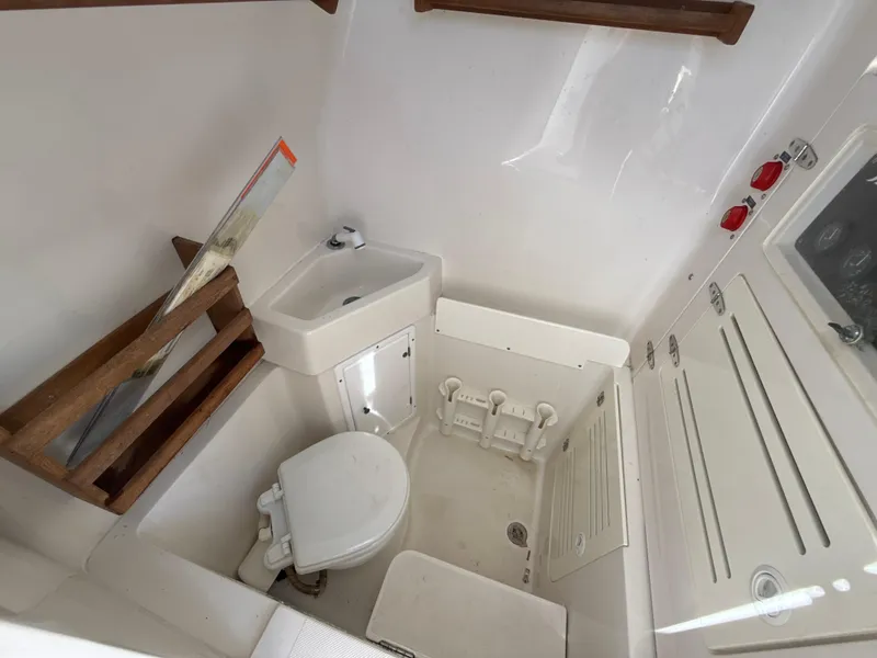 Slide: The Image of Compact boat bathroom with toilet, sink, and storage in a 2008 Jupiter 38 model. - 23
