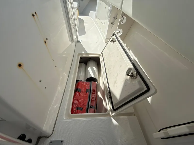 Slide: The Image of Open storage compartment on 2008 Jupiter 38 boat, containing safety equipment. - 26