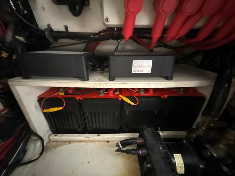 Slide: The Image of Battery compartment of a 2008 Jupiter 38 boat, featuring multiple batteries and wiring. - 30