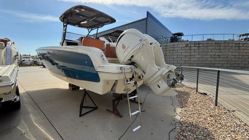 Slide: The Image of 2024 Capoforte FX270 boat with outboard motor, docked on a sunny day. - 2