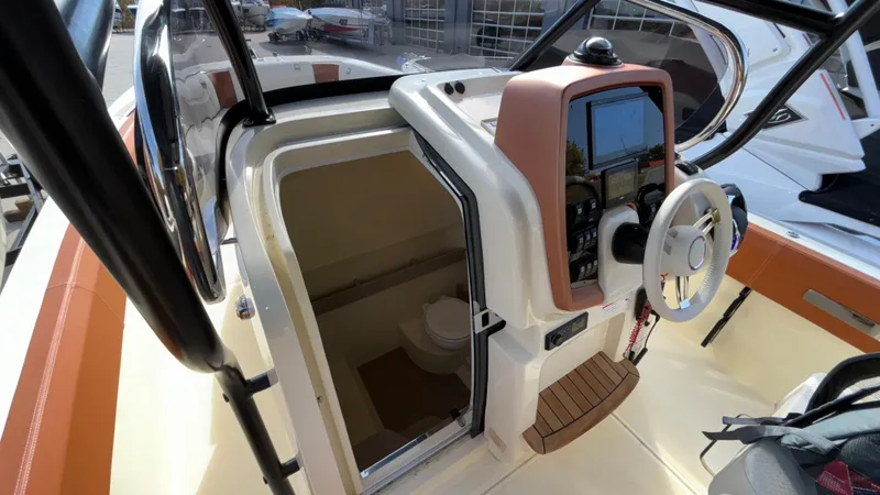 Slide: The Image of 2024 Capoforte FX270 boat interior with helm and cabin entrance. - 45