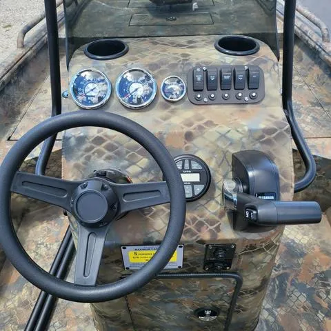 Slide: The Image of 2025 Excel 1860SWV4 Shallow Water F4 Console, camo design, steering wheel, gauges, and controls. - 12