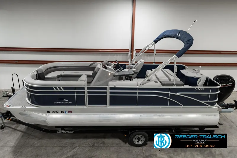 Slide: The Image of 2021 Bennington 22SX pontoon boat on trailer, side view in indoor setting. - 1