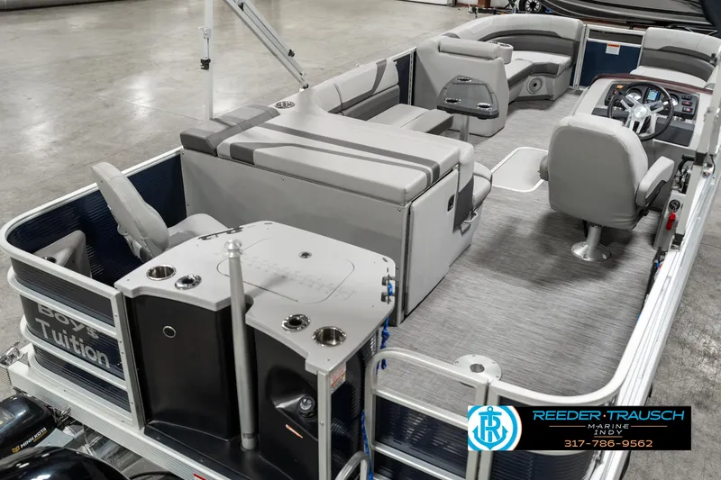 Slide: The Image of 2021 Bennington 22SX pontoon boat interior with seating and helm, showcased in showroom. - 11