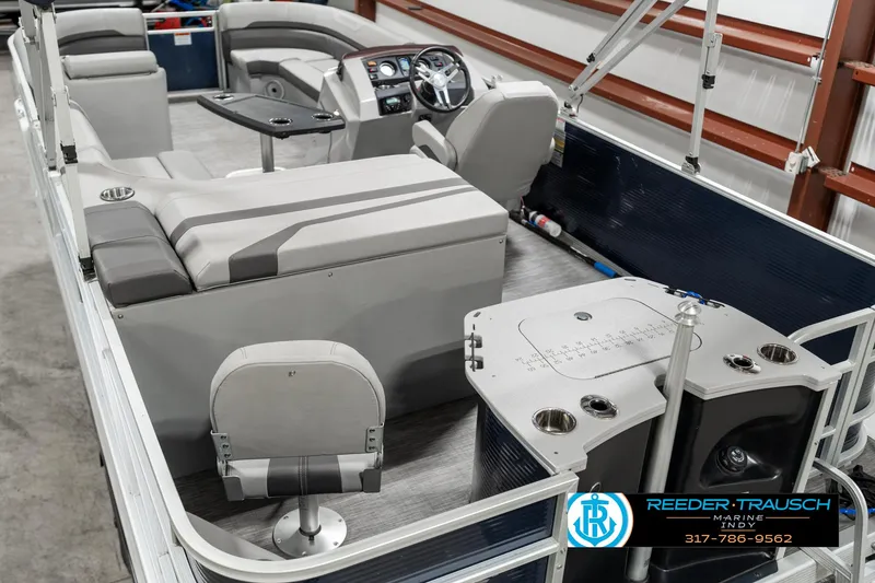 Slide: The Image of 2021 Bennington 22SX pontoon boat interior with seating and helm, showcased indoors. - 12