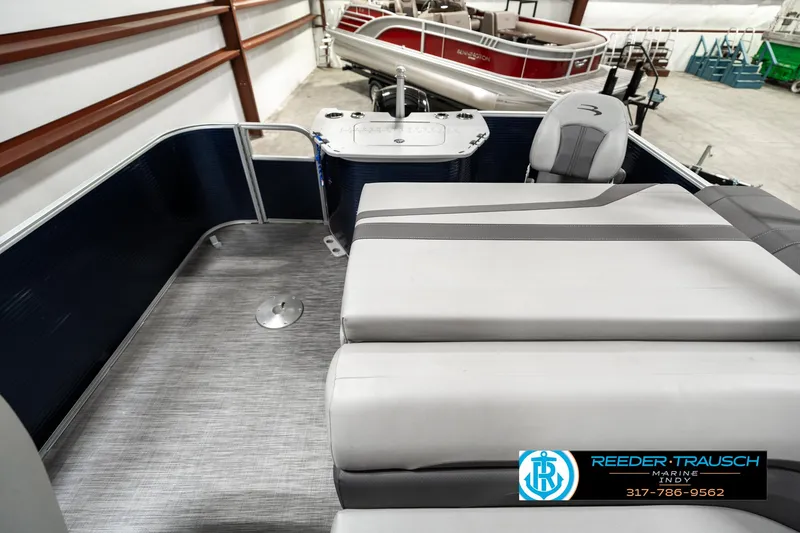 Slide: The Image of 2021 Bennington 22SX pontoon boat interior with seating and helm, in showroom. - 15