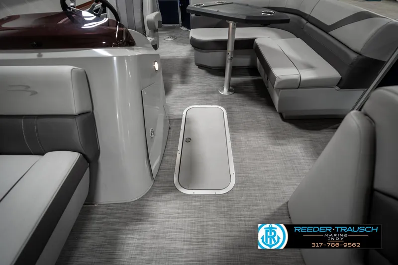 Slide: The Image of 2021 Bennington 22SX boat interior with gray seating and flooring, featuring a storage hatch. - 22