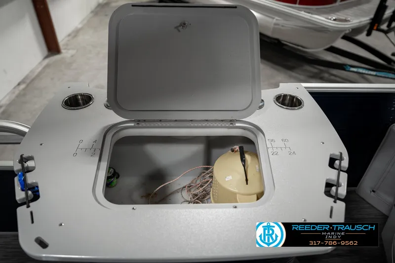 Slide: The Image of Open storage compartment on 2021 Bennington 22SX boat with cup holders. - 30
