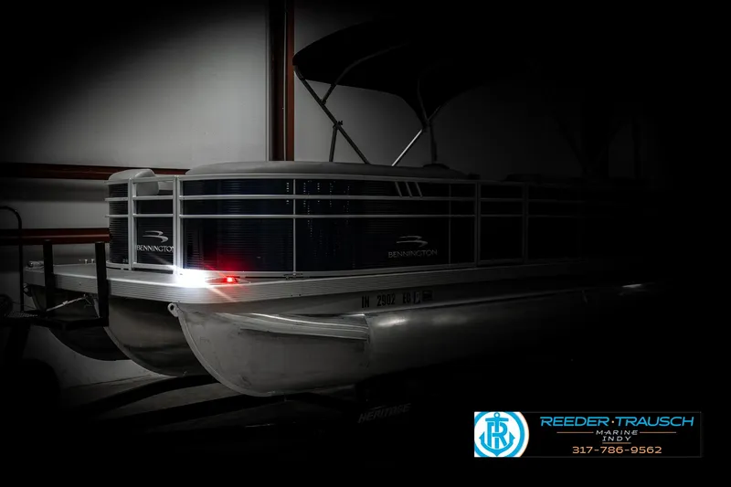 Slide: The Image of 2021 Bennington 22SX pontoon boat in dimly lit indoor storage. - 4