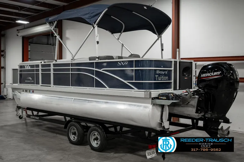 Slide: The Image of 2021 Bennington 22SX pontoon boat with Mercury outboard motor in a warehouse. - 6