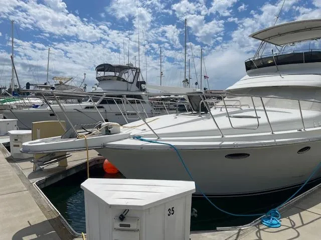 Slide: The Image of 1990 Trojan 40 Sport Fisherman 3208 Cat Diesel docked at marina under blue sky. - 10