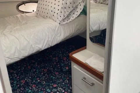 Slide: The Image of 1990 Trojan 40 Sport Fisherman cabin with bed, floral carpet, and mirror. - 14