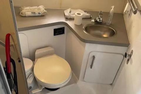 Slide: The Image of Compact bathroom in a 1990 Trojan 40 Sport Fisherman boat, featuring a toilet and sink. - 15
