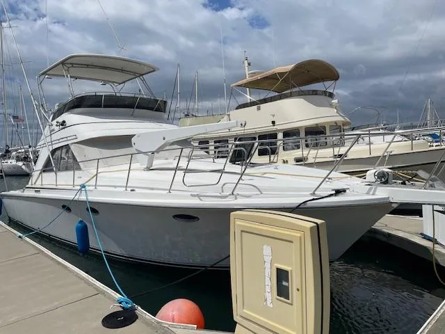 Slide: The Image of 1990 Trojan 40 Sport Fisherman 3208 Cat Diesel docked at marina. - 2