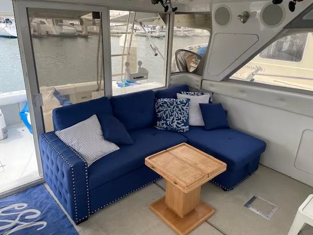 Slide: The Image of Interior of 1990 Trojan 40 Sport Fisherman with blue sofa and wooden table. - 3