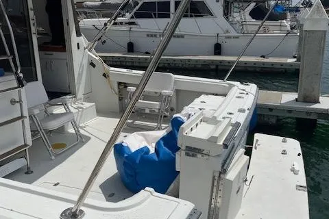 Slide: The Image of 1990 Trojan 40 Sport Fisherman boat docked, featuring spacious deck and seating area. - 7