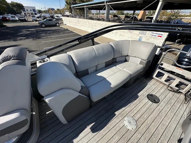 Slide: The Image of 2020 Ranger 2300LS boat with gray seating and spacious deck in a parking lot. - 22