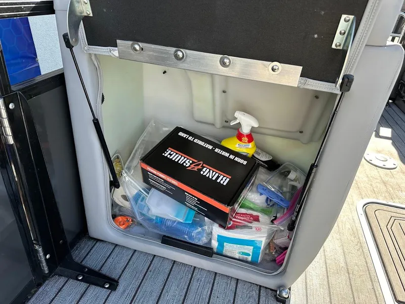 Slide: The Image of Storage compartment in a 2020 Ranger 2300LS boat with cleaning supplies and tools. - 38
