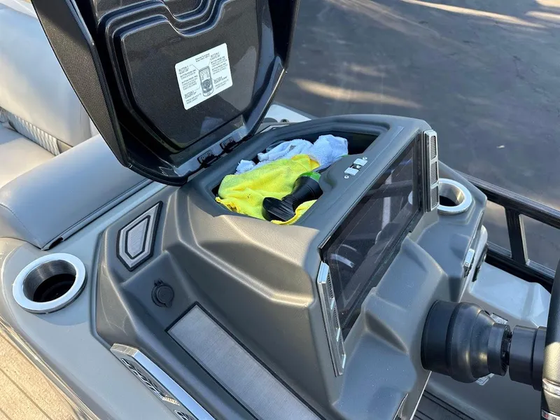 Slide: The Image of Open storage compartment on 2020 Ranger 2300LS boat dashboard with items inside. - 49