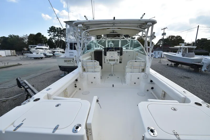Slide: The Image of 2008 World Cat 32 EC boat interior, spacious deck, and helm station in a marina setting. - 13