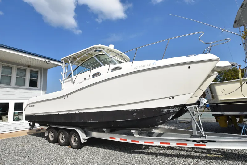 Slide: The Image of 2008 World Cat 32 EC boat on trailer, parked near a building under blue sky. - 18