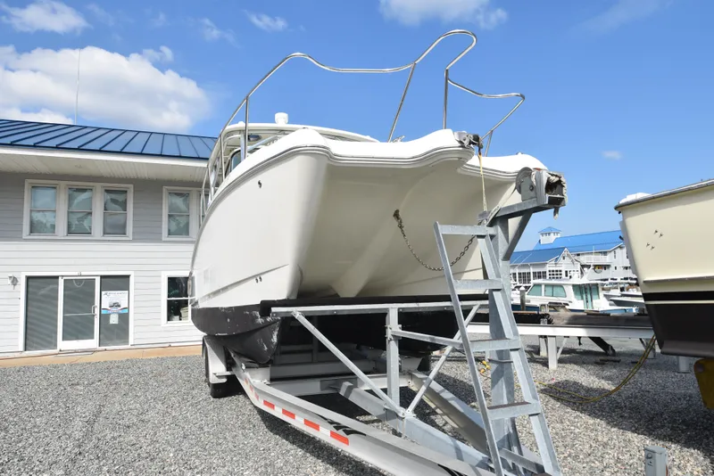 Slide: The Image of 2008 World Cat 32 EC boat on trailer, parked near marina buildings. - 3