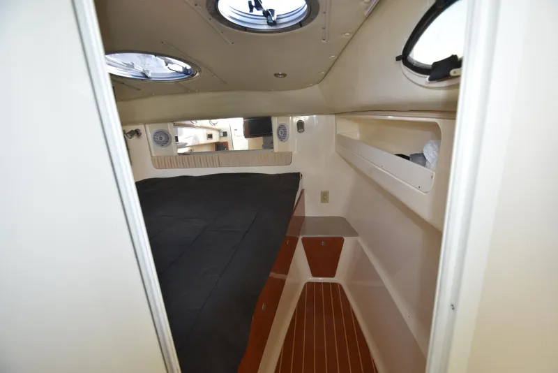 Slide: The Image of 2008 World Cat 32 EC cabin interior with bed, portholes, and storage shelves. - 32